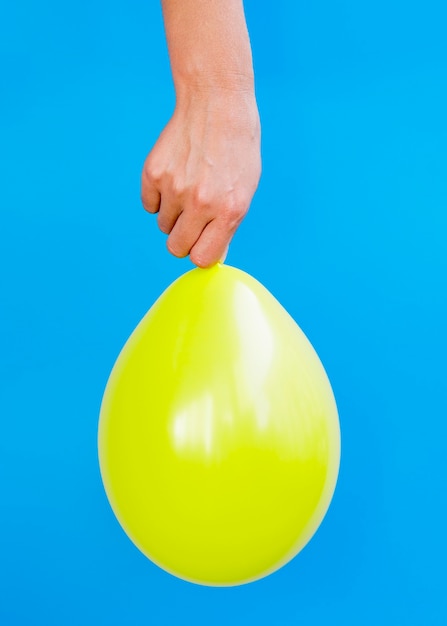 Foto gratuita persona con globo amarillo brillante