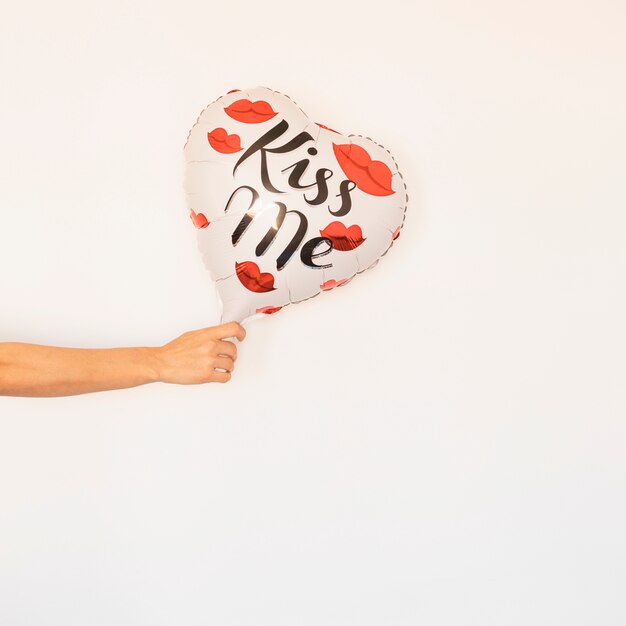 Persona con globo de corazón en la mano