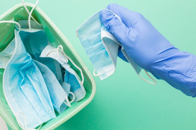 Persona con guantes de protección teniendo una mascarilla desechable