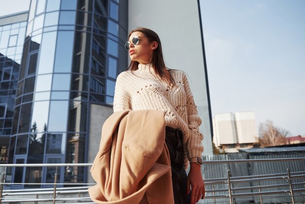 Una persona. Hermosa joven en ropa de abrigo tiene caminar en la ciudad en su tiempo de los fines de semana