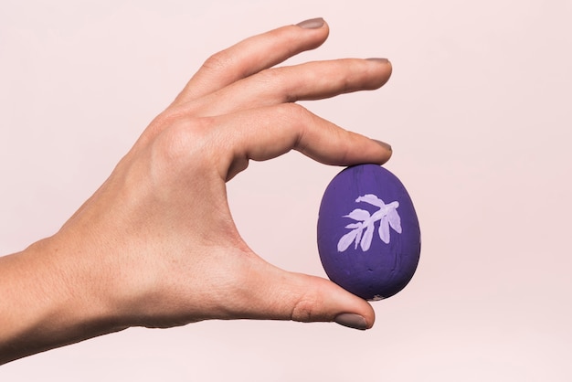 Persona con huevo de Pascua brillante en la mano