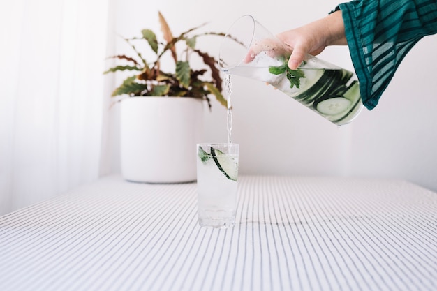 Persona irreconocible que vierte agua refrescante