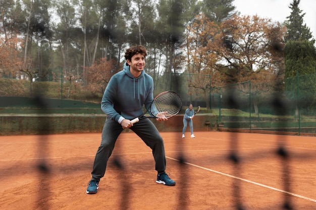 Persona jugando tenis en invierno