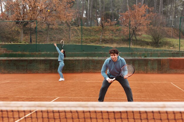 Persona jugando tenis en invierno