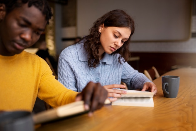 Foto gratuita persona leyendo un libro en un café