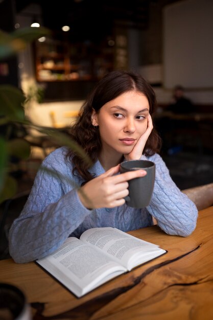 Persona leyendo un libro en un café