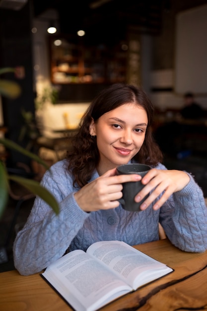 Persona leyendo un libro en un café