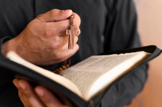 Foto gratuita persona con libro sagrado y rosario