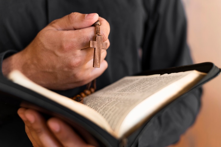 Foto gratuito persona con libro sagrado y rosario