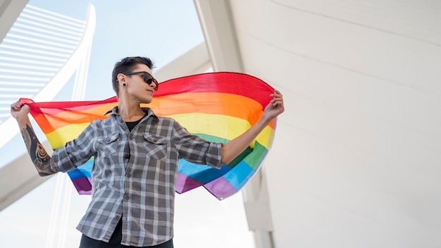 Foto gratuita persona manteniendo la bandera del arco iris