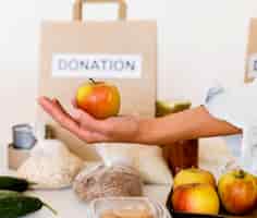 Foto gratuita persona con manzana para donación de caridad