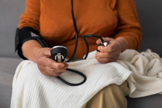 Persona mayor comprobando su presión arterial con tensiómetro