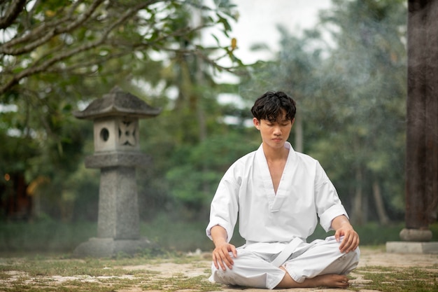 Persona meditando antes del entrenamiento de taekwondo