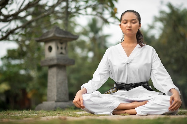 Foto gratuita persona meditando antes del entrenamiento de taekwondo