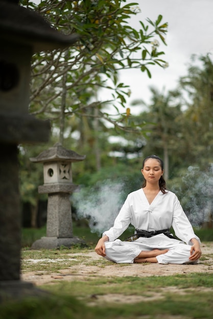 Foto gratuita persona meditando antes del entrenamiento de taekwondo