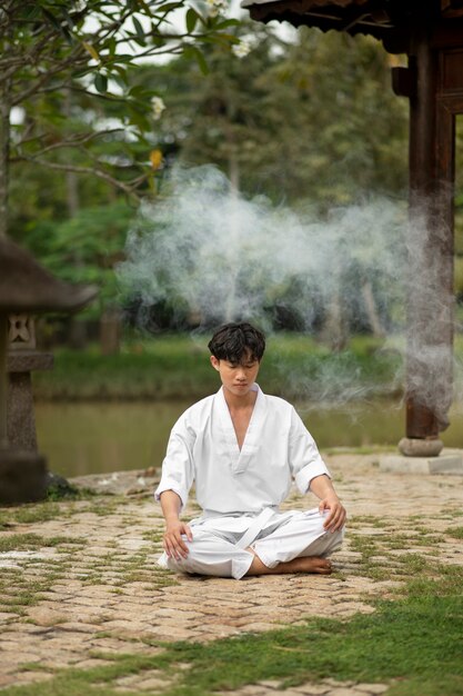 Persona meditando antes del entrenamiento de taekwondo