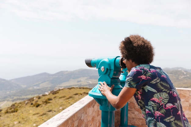 Foto gratuita persona mirando al paisaje con binoculares