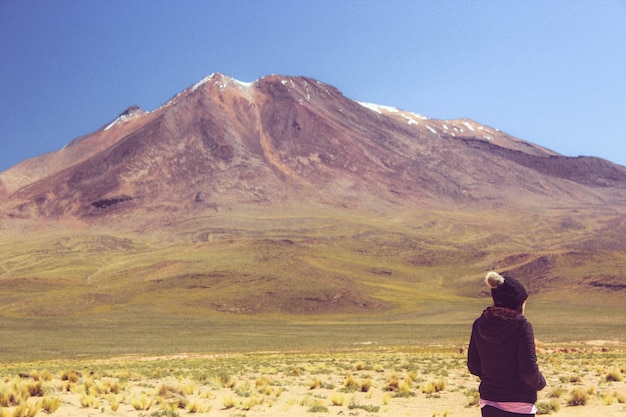 Foto gratuita persona mirando una enorme montaña