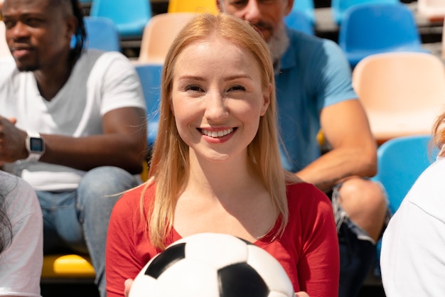 Persona mirando un partido de fútbol en un día soleado