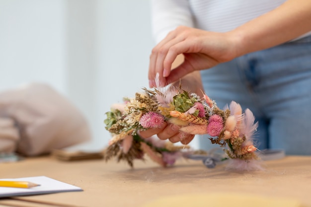 Persona de negocios de primer plano creando una corona de flores