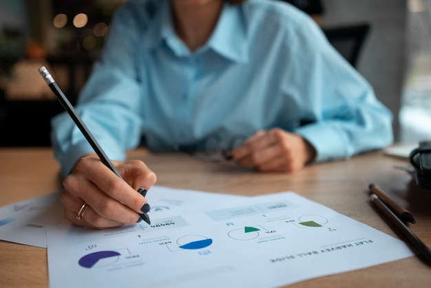 Foto gratuita persona en la oficina analizando y revisando gráficos financieros