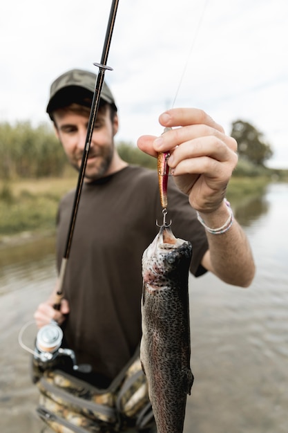 Foto gratuita persona pescando un pez con una caña de pescar