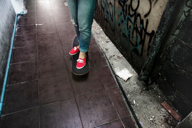 Foto gratuita persona de pie en patineta en callejón al lado