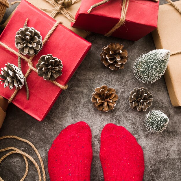 Persona de pie en el piso con cajas de regalo.