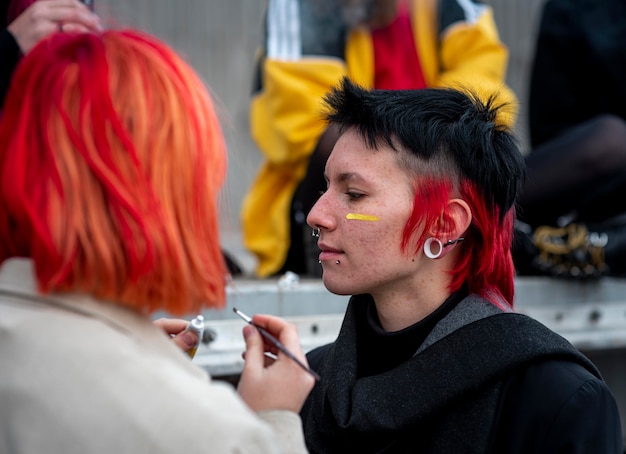 Foto gratuita persona pintando una bandera no binaria en un amigo