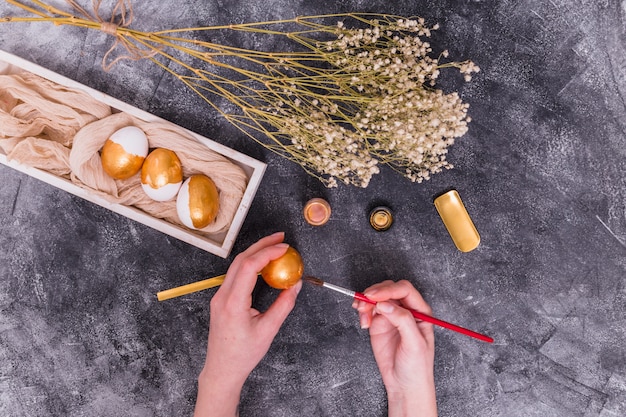 Foto gratuita persona pintando huevos para pascua