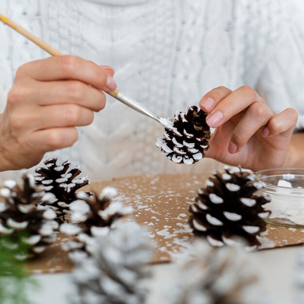 Persona pintando piñas para navidad