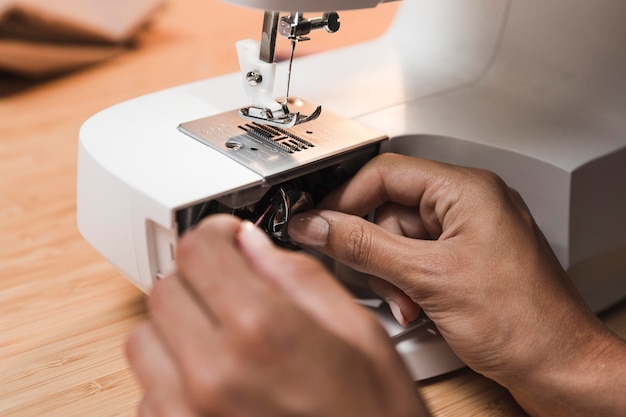 Persona poniendo hilo en una máquina de coser