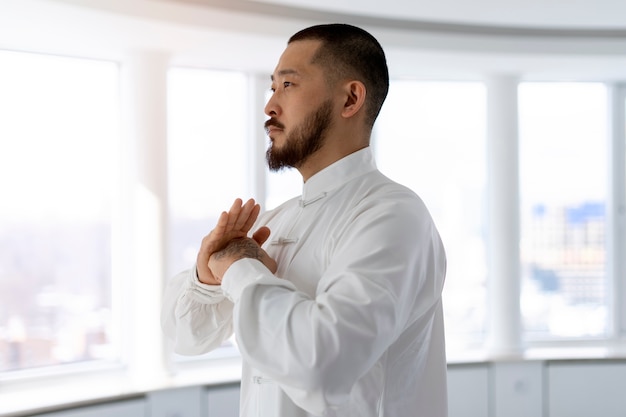 Foto gratuita persona practicando tai chi en interiores