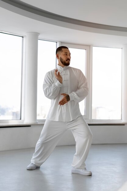 Foto gratuita persona practicando tai chi en interiores