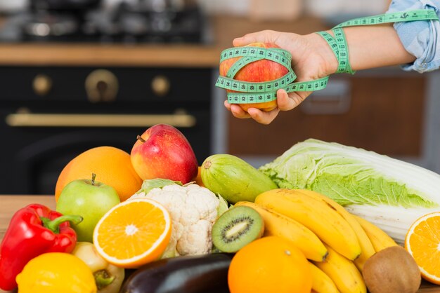 Persona de primer plano con arreglo de frutas