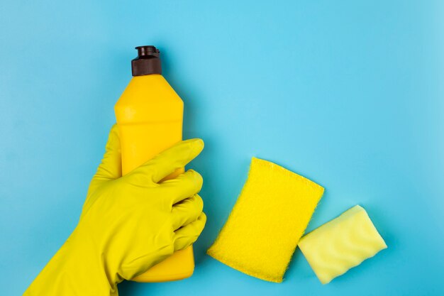 Persona de primer plano con botella de detergente amarillo