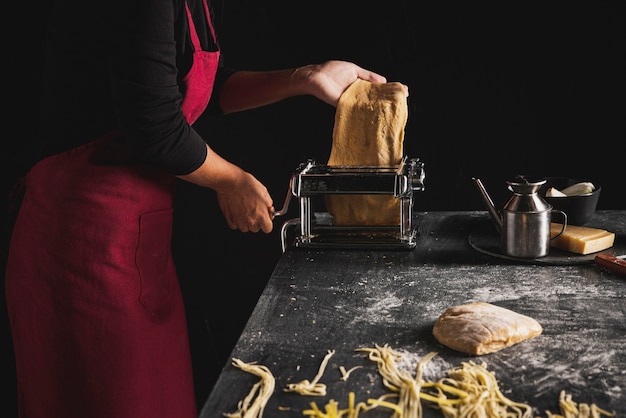 Persona de primer plano con delantal rojo y masa