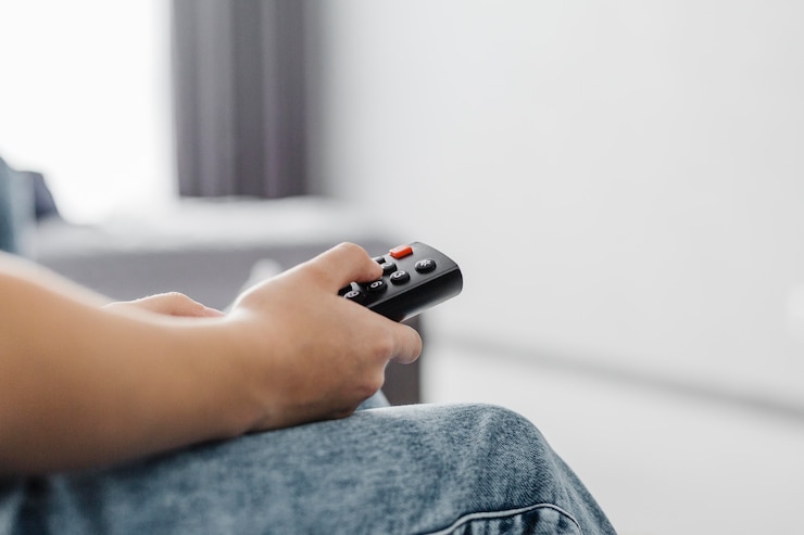 Foto gratuito persona de primer plano con el mando a distancia de la televisión