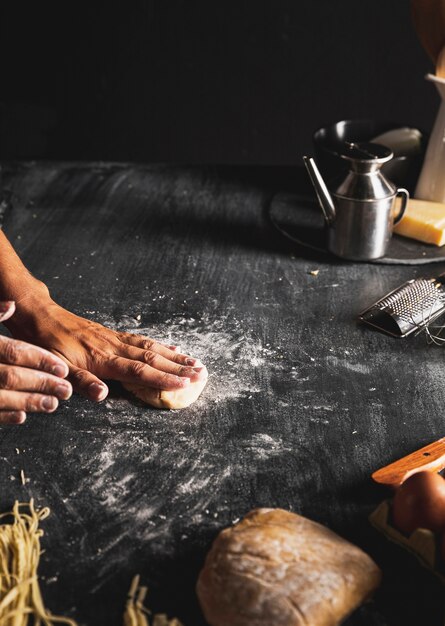 Persona de primer plano con masa y mesa negra