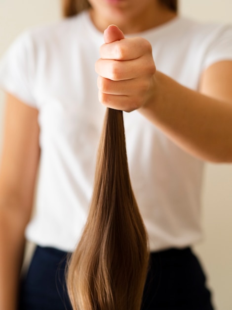 Foto gratuita persona de primer plano sosteniendo el cabello
