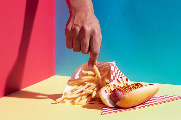 Foto gratuita persona de primer plano sosteniendo una patata frita