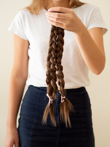 Foto gratuita persona de primer plano sosteniendo trenzas