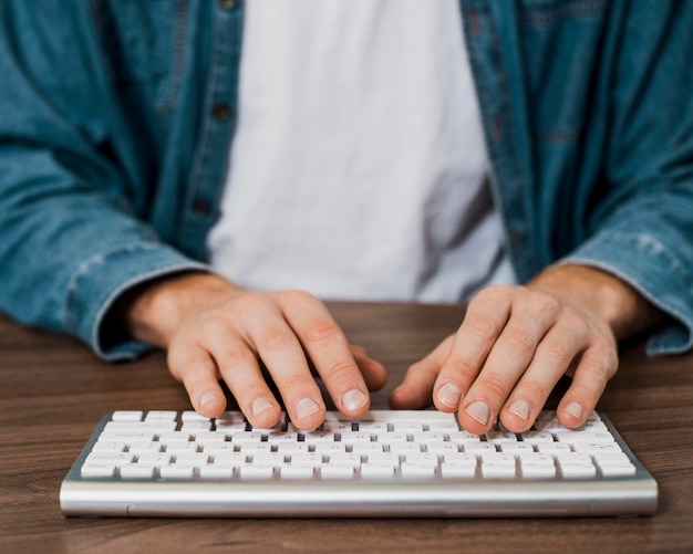 Persona de primer plano con un teclado mac inalámbrico