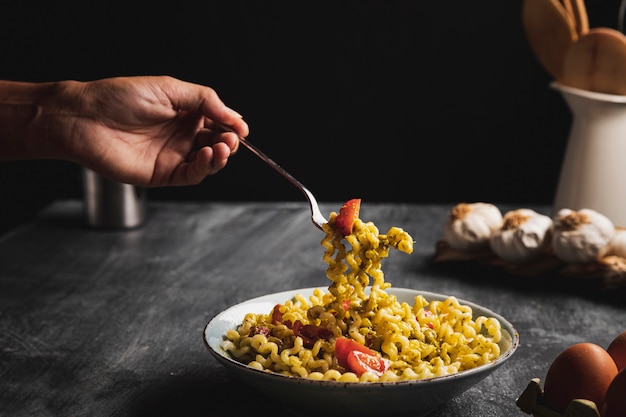 Persona de primer plano con tenedor y pasta