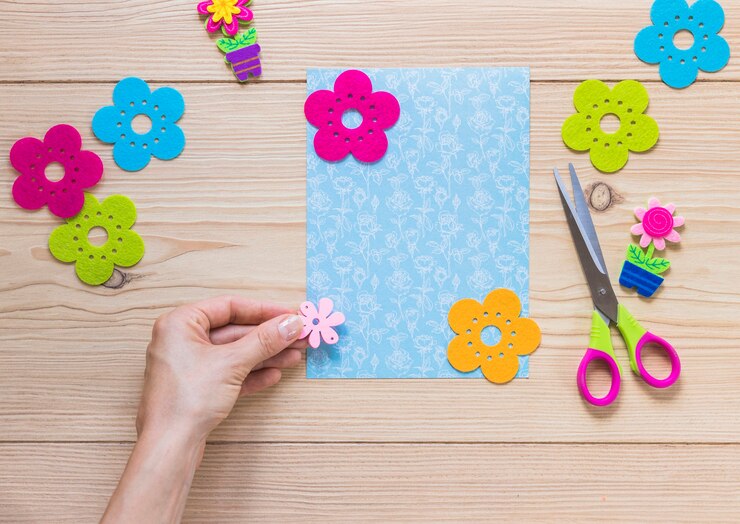 Foto gratuito una persona que adorna la tarjeta con el parche colorido de la flor