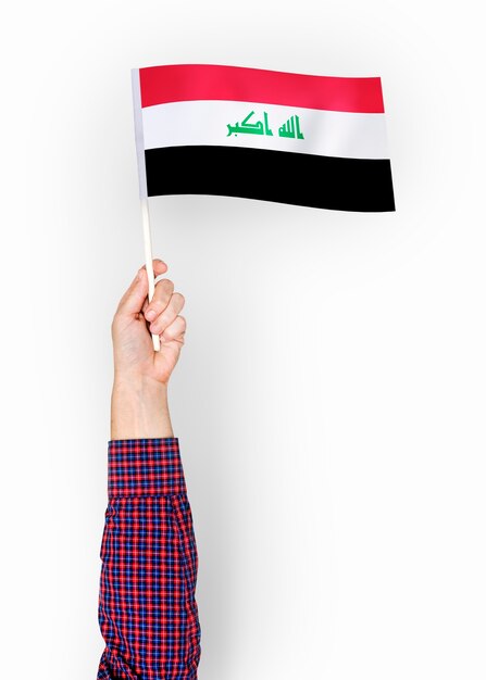Persona que agita la bandera de la República de Iraq