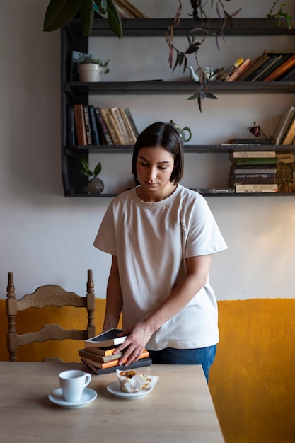 Foto gratuita persona que disfruta leyendo un libro en un café.