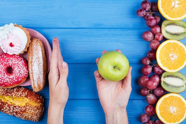 Persona que elige alimentos saludables en lugar de dulces