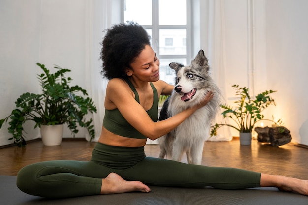 Foto gratuita persona que hace yoga acompañada de su mascota