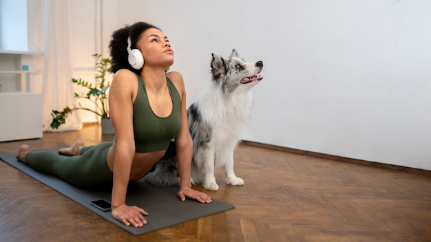 Foto gratuita persona que hace yoga acompañada de su mascota